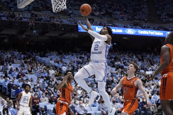North Carolina guard Caleb Love (2) drives to the basket while Virginia Tech guard Darius Maddox (13) and guard Sean Pedulla (3) look on during the first half of an NCAA college basketball game in Chapel Hill, N.C., Monday, Jan. 24, 2022. (AP Photo/Gerry Broome)