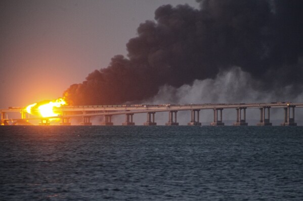 Flames and smoke rise from a bridge connecting Crimea and Russia in Kerch, on the Crimean peninsula, Oct. 8, 2022. (AP Photo, File)