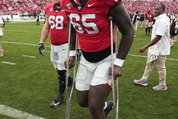 Georgia offensive lineman Amarius Mims uses crutches to leave the field after defeasting South Carolina an NCAA college football game Saturday, Sept. 16, 2023, Ga. Mims wa injured in the firt half. (AP Photo/John Bazemore)