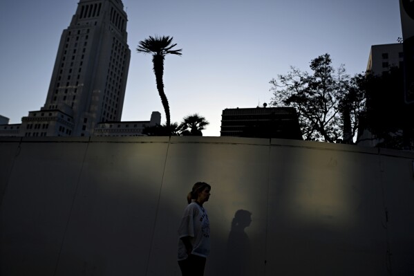 A woman walks in the quiet streets of downtown across the from the Robert Young federal building Tuesday, June 17, 2025, in Los Angeles. (AP Photo/Wally Skalij)