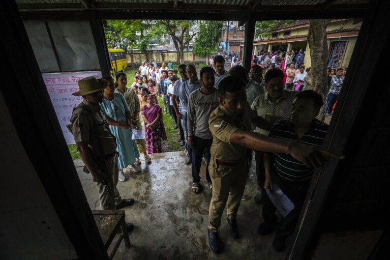 People queue up to cast their votes in a polling station during the third phase of general election in Guwahati, Assam, India, Tuesday, May 7, 2024. (AP Photo/Anupam Nath)