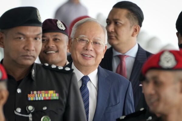Former Malaysian Prime Minister Najib Razak arrives at the Kuala Lumpur High Court complex escorted by prison officers in Kuala Lumpur, Malaysia, on Thursday, April 4, 2024. (AP Photo/Vincent Thian)