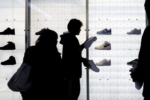 FILE - People shop for Nike shoes at a store on Nov. 25, 2022, in New York. A popular form of payment by installment 鈥� 'buy now, pay later' 鈥� is projected to have its biggest holiday season yet. But analysts caution more transparency is needed in the space to prevent consumers from over-extending themselves if they take on multiple loans. (AP Photo/Julia Nikhinson, File)