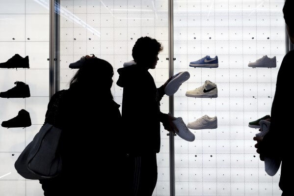 FILE - People shop for Nike shoes at a store on Nov. 25, 2022, in New York. A popular form of payment by installment — 'buy now, pay later' — is projected to have its biggest holiday season yet. But analysts caution more transparency is needed in the space to prevent consumers from over-extending themselves if they take on multiple loans. (Ǻ Photo/Julia Nikhinson, File)