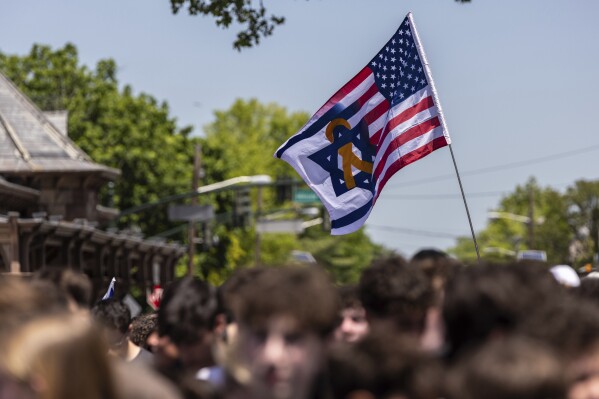 An Israeli-American flag flies in Huyler Park as people gather to celebrate the release of American hostage Edan Alexander from Hamas on Monday, May 12, 2025, in Tenafly, N.J. (AP Photo/Stefan Jeremiah)