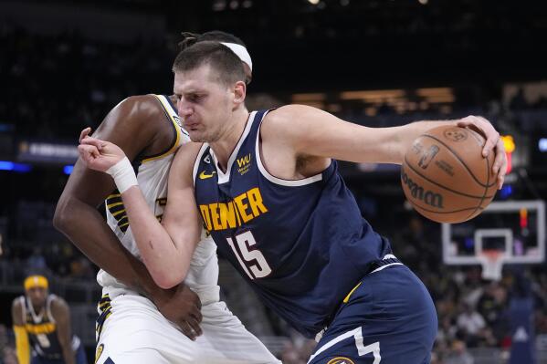 Denver Nuggets' Nikola Jokic (15) goes to the basket against Indiana Pacers' Myles Turner during the first half of an NBA basketball game, Wednesday, Nov. 9, 2022, in Indianapolis. (AP Photo/Darron Cummings)