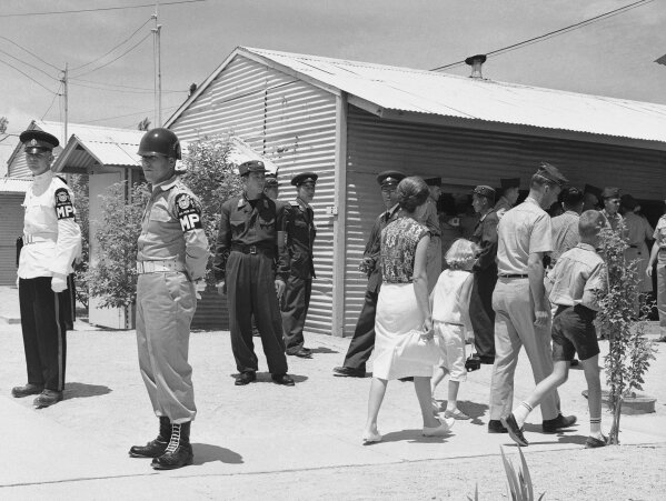 
              FILE - Walking past United Nations and North Korean guards on duty, sightseers flock around the building in which the Military Armistice Commission meets in the Demilitarized Zone at Panmunjom, Korea, on July 8, 1963. (AP Photo/KIM, File)
            