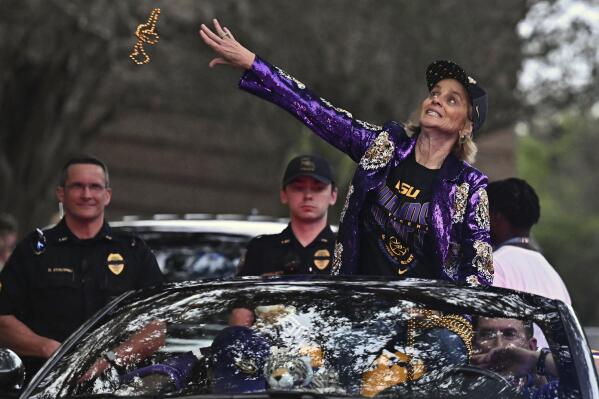 LSU head coach Kim Mulkey throws beads into the crowd as the women's NCAA college national champion basketball team paraded across campus in Baton Rouge, La., Wednesday, April 5, 2023. (Hilary Scheinuk/The New Orleans Advocate via AP)