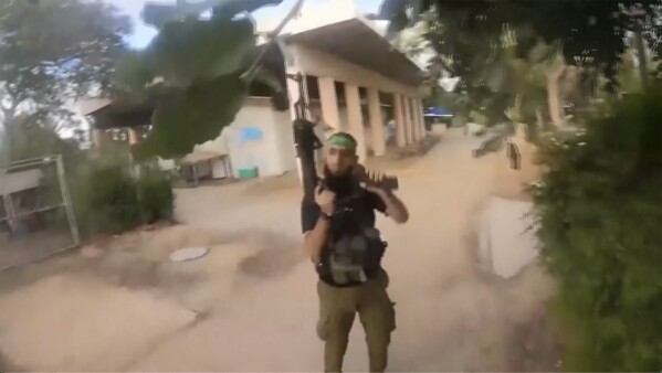 This image made from undated bodycam video footage taken by a downed Hamas militant and released by Israel Defense Forces shows a Hamas militant walking around a residential neighborhood at an undisclosed location in southern Israel. Israel's military brought together a group of foreign correspondents Monday, Oct. 16, 2023, to screen a 40-minute reel of gruesome footage compiled from the Hamas attack last week. The screening came as Israel's military faces increasing pressure to back up their claims of atrocities committed by the militants. (Israel Defense Forces via AP)
