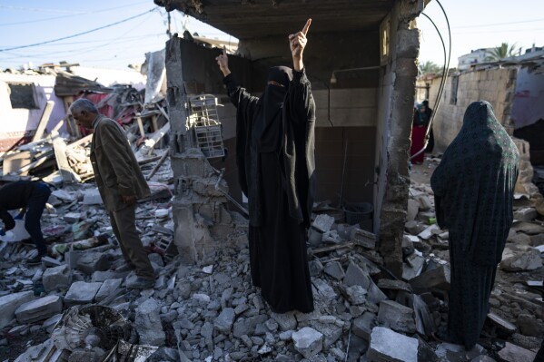 Palestinians look at the destruction after an Israeli strike in Rafah, southern Gaza Strip, Thursday, Jan. 18, 2024. (AP Photo/Fatima Shbair)
