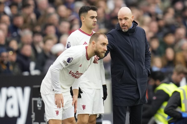 Manchester United's head coach Erik ten Hag talks to Manchester United's Sergio Reguilon, centre, and Manchester United's Christian Eriksen during the English Premier League soccer match between West Ham United and Manchester United at the London stadium in London, Saturday, Dec. 23, 2023. (AP Photo/Kirsty Wigglesworth)