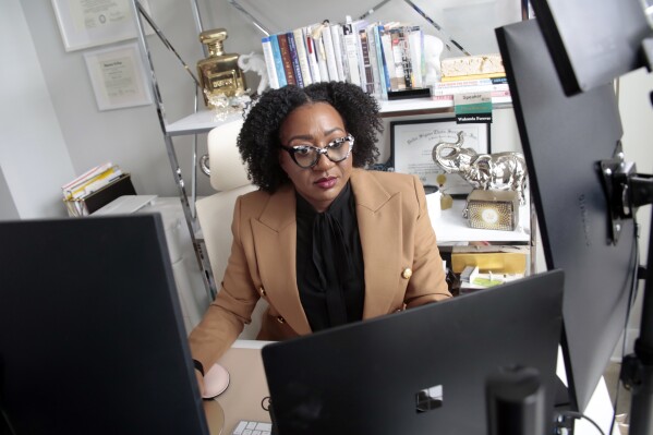 Chantel Adams, a senior marketing executive, sits in her home office Thursday, March 7, 2024, in Durham, N.C. Adams says she isn’t surprised that the gender pay gap persists even among men and women with the same level and quality of education, or that the gap is wider for Black and Hispanic women. (AP Photo/Chris Seward)