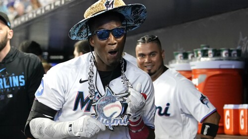 Miami Marlins' Jesus Sanchez celebrates in the dugout after hitting a two-run home run during the first inning of a baseball game against the Philadelphia Phillies, Sunday, July 9, 2023, in Miami. (AP Photo/Lynne Sladky)