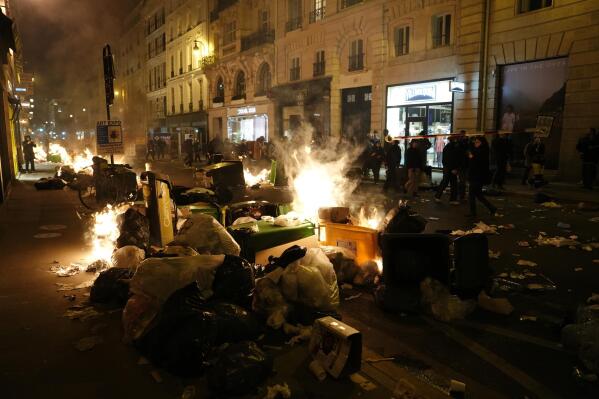 FILE - Piles of uncollected garbage is set on fire by protesters after a demonstration near Concorde square, in Paris, March 16, 2023. (AP Photo/Lewis Joly, File)