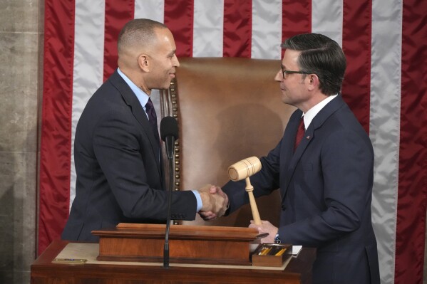 House Minority Leader Hakeem Jeffries, D-N.Y., left, hands the gavel to House Speaker Mike Johnson, R-La., in a customary nod to the peaceful transfer of power as the House of Representatives meets to elect a speaker and convene the new 119th Congress at the Capitol in Washington, Friday, Jan. 3, 2025. (AP Photo/Jacquelyn Martin)