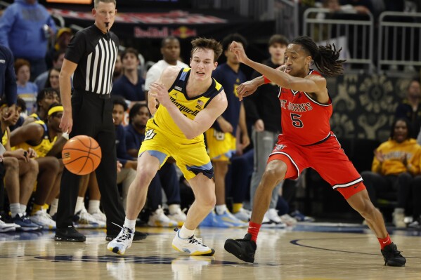 Marquette's Tyler Kolek (11) and St. John's RJ Luis Jr. 5) chase the ball during the second half of an NCAA college basketball game Saturday, Feb. 10, 2024, in Milwaukee. (AP Photo/Jeffrey Phelps)