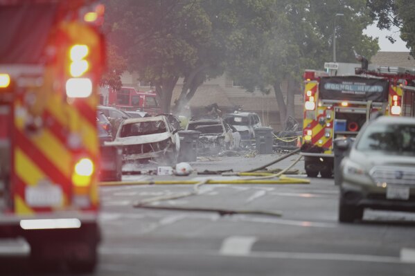 Authorities work the scene where a small plane crashed into a San Diego neighborhood, setting several homes on fire and forcing evacuations along several blocks early Thursday, May 22, 2025. (AP Photo/Gregory Bull)