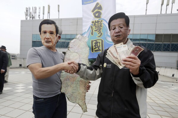 Protesters wearing masks of former Taiwanese President Ma Ying-jeou, left, and Chinese President Xi Jinping, right, perform, as Ma leaves for China outside of Taoyuan International Airport in Taoyuan City, Northern Taiwan, Monday, April 1, 2024. (AP Photo/Chiang Ying-ying)