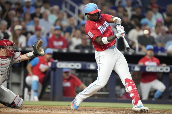 Miami Marlins' Jean Segura runs to beat the throw by Philadelphia Phillies  second baseman Bryson Stott but is out at the plate during the eighth  inning of a baseball game, Sunday, July
