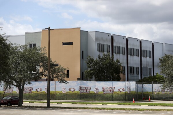 FILE - The 1200 building at Marjory Stoneman Douglas High School in Parkland, Fla., is seen, Oct. 20, 2021. The school building where 14 students and three staff members were fatally shot in a 2018 massacre is set to be demolished next summer, officials announced Thursday, Sept. 21, 2023. The demolition of Marjory Stoneman Douglas High School’s 1200 building, which has remained closed and locked behind a fence since the shooting, is scheduled to take place immediately following the conclusion of the school year. (Carline Jean/South Florida Sun-Sentinel via AP, File)