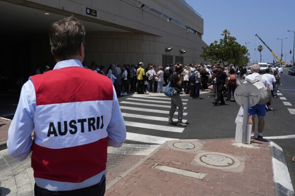Citizens of Poland and Austria assemble at a hotel in Tel Aviv, Israel, for evacuation amid heavy strikes on Israel by Iran Tuesday, June 17, 2025. (AP Photo/Baz Ratner)