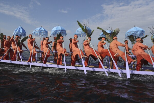 Inntha ethnic people row on a long boat in a procession carrying Buddha images to a monastery during the pagoda festival Thursday, Oct. 19, 2023, in Inlay Lake, southern Shan State, Myanmar. (AP Photo/Thein Zaw)