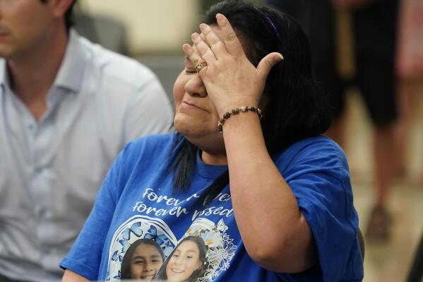 Leticia Cobarrubia, aunt of shooting victims Jackie Cazares and Annabell Roidriguez, wipes away tears as she listens to the Texas House investigative committee release its full report on the shootings at Robb Elementary School, Sunday, July 17, 2022, in Uvalde, Texas. (AP Photo/Eric Gay)