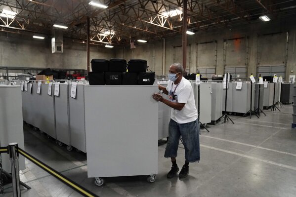 An election warehouse worker moves polling place equipment at the Clark County Election Department in North Las Vegas, Nev., Friday, Nov. 6, 2020.(AP Photo/Jae C. Hong)