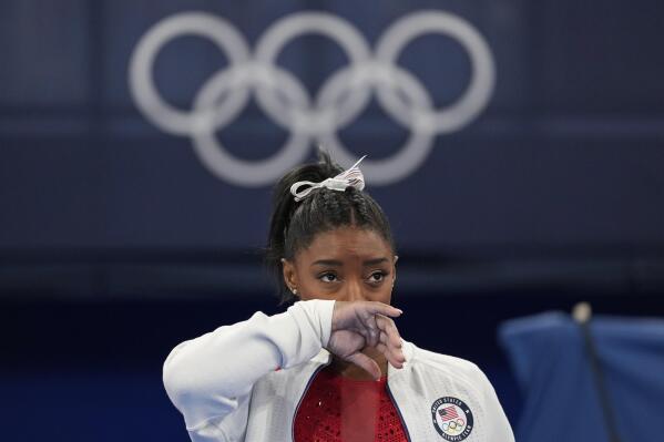 FILE - Simone Biles watches gymnasts perform at the 2020 Summer Olympics in Tokyo, Tuesday, July 27, 2021. Simone Biles and Naomi Osaka were not the first elite athletes to struggle with their own mental health, but their public admissions this year spotlighted a crisis not often addressed in the sporting world. (AP Photo/Ashley Landis, File)