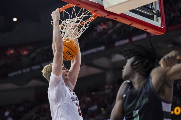 Wisconsin's Steven Crowl (22) dunks next to Chicago State's Wesley Cardet (1) during the second half of an NCAA college basketball game Friday, Dec. 22, 2023, in Madison, Wis. (AP Photo/Andy Manis)