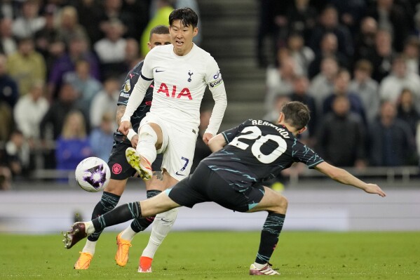 Tottenham's Son Heung-min, left, and Manchester City's Bernardo Silva challenge for the ball during the English Premier League soccer match between Tottenham Hotspur and Manchester City at Tottenham Hotspur Stadium in London, Tuesday, May 14, 2024.(AP Photo/Kin Cheung)