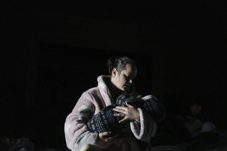 A woman holds a baby in a bomb shelter in Mariupol, Ukraine, Tuesday, March 8, 2022. (AP Photo/Evgeniy Maloletka)