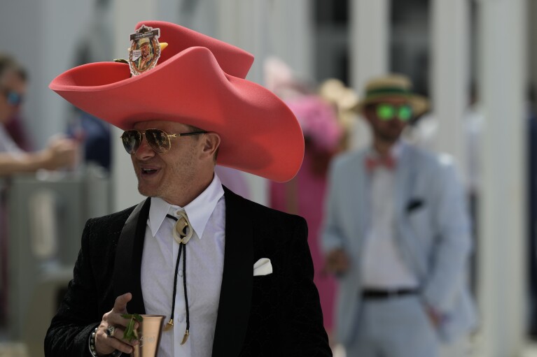 Race fans walk though the grounds of Churchill Downs before the 150th running of the Kentucky Derby horse race Saturday, May 4, 2024, in Louisville, Ky. (AP Photo/Charlie Riedel)
