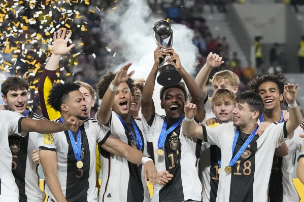 Team Germany celebrates on the podium with their trophy after their victory over France in the U-17 World Cup final soccer match at Manahan Stadium in Surakarta, Indonesia, Saturday, Dec. 2, 2023. (AP Photo/Achmad Ibrahim)
