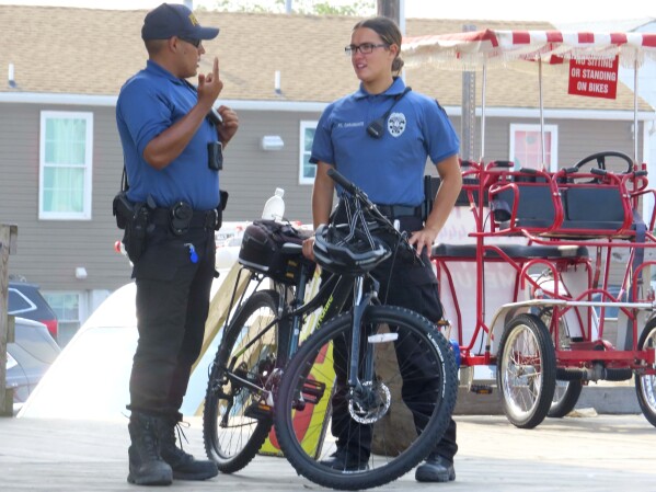 Bicycle police officers rest while patrolling the boardwalk in Seaside Heights, N.J., on Thursday, June 29, 2023. Officials and residents of several New Jersey shore towns say the state’s law decriminalizing marijuana use is having an unintended effect: emboldening large groups of teenagers to run amok on beaches and boardwalks, knowing there is little chance of them getting in trouble for it. (AP Photo/Wayne Parry)