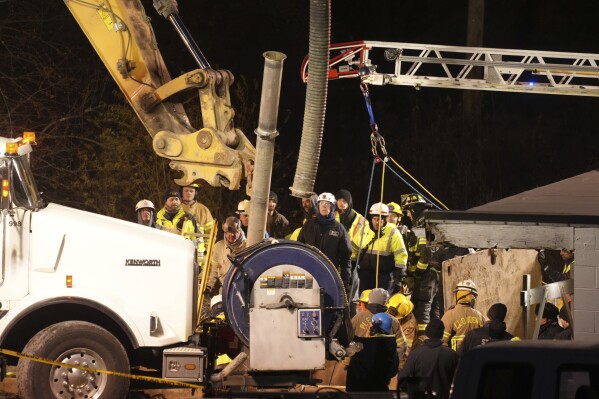 Rescue workers search in a sinkhole for Elizabeth Pollard, who disappeared while looking for her cat, in Marguerite, Pa., Tuesday, Dec. 3, 2024. (AP Photo/Gene J. Puskar)