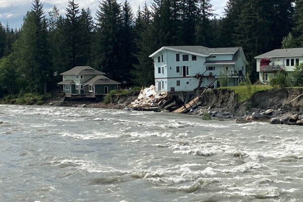 The swollen Mendenhall River courses along a neighborhood in Juneau, Alaska, on Sunday, Aug. 6, 2023, after a glacial dam burst earlier in the weekend caused flooding along the river and Mendenhall Lake. The city said at least two buildings were destroyed. (AP Photo/BeckyBohrer)