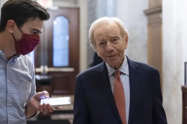 Former Sen. Joe Lieberman of Conn., right, speaks with a reporter as the Senate prepares for a key test vote on the For the People Act, a sweeping bill that would overhaul the election system and voting rights, at the Capitol in Washington, Tuesday, June 22, 2021. The bill is a top priority for Democrats seeking to ensure access to the polls and mail in ballots, but it is opposed by Republicans as a federal overreach. (AP Photo/Alex Brandon)