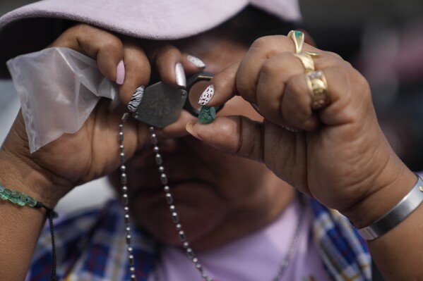 A trader inspects a piece of emerald in Coscuez Colombia, Friday, March 1, 2024. The gems are one of the nation’s most iconic products, and are sold in dozens of jewelry shops in cities like Cartagena and Bogotá. (AP Photo/Fernando Vergara)