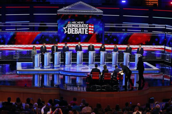 CORRECTS BENNET'S TITLE TO SENATOR, INSTEAD OF FORMER SENATOR - Democratic presidential candidates, author Marianne Williamson, former Colorado Gov. John Hickenlooper, entrepreneur Andrew Yang, South Bend Mayor Pete Buttigieg, former Vice President Joe Biden, Sen. Bernie Sanders, I-Vt., Sen. Kamala Harris, D-Calif., Sen. Kirsten Gillibrand, D-N.Y., Colorado Sen. Michael Bennet, and Rep. Eric Swalwell, D-Calif., listen to a question during a Democratic primary debate hosted by NBC News at the Adrienne Arsht Center for the Performing Arts, Thursday, June 27, 2019, in Miami. (AP Photo/Wilfredo Lee)
