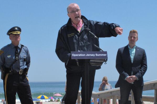 New Jersey Gov. Phil Murphy, center, speaks at a news conference at Island Beach State Park in New Jersey on Wednesday, May 19, 2021, where he announced that the state will give free season-long admission to the park and other state parks to any New Jersey resident who has gotten at least one dose of COVID-19 vaccine by July 4. Other incentives to get people to take the shot include a free glass of wine at participating wineries. (AP Photo/Wayne Parry)