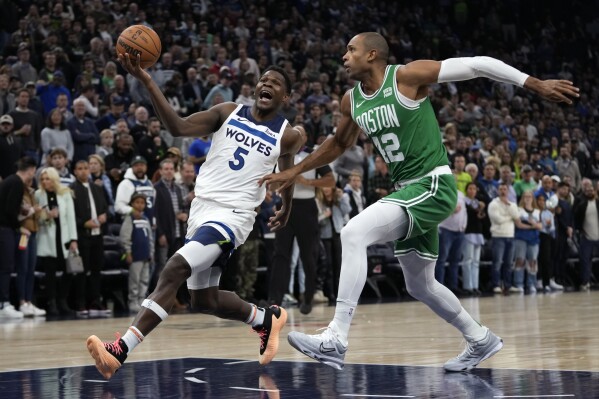 Minnesota Timberwolves guard Anthony Edwards (5) works toward the basket as Boston Celtics center Al Horford defends during the first half of an NBA basketball game, Monday, Nov. 6, 2023, in Minneapolis. (AP Photo/Abbie Parr)