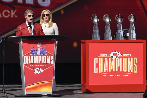 Kansas City Chiefs chairman and CEO Clark Hunt, with his wife Tavia Shackels Hunt, speak to the crowd during their victory rally in Kansas City, Mo., Wednesday, Feb. 14, 2024. The Chiefs defeated the San Francisco 49ers Sunday in the NFL Super Bowl 58 football game. (AP Photo/Reed Hoffmann)