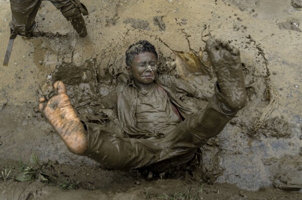 A boy plays in the mud in a paddy field during Asar Pandra, or paddy planting day at Bahunbesi, Nuwakot District, 30 miles North from Kathmandu, Nepal, Friday, June 30, 2023. Nepalese people celebrate the festival by planting paddy, playing in the mud, singing traditional songs, eating yogurt and beaten rice.(AP Photo/Niranjan Shrestha)