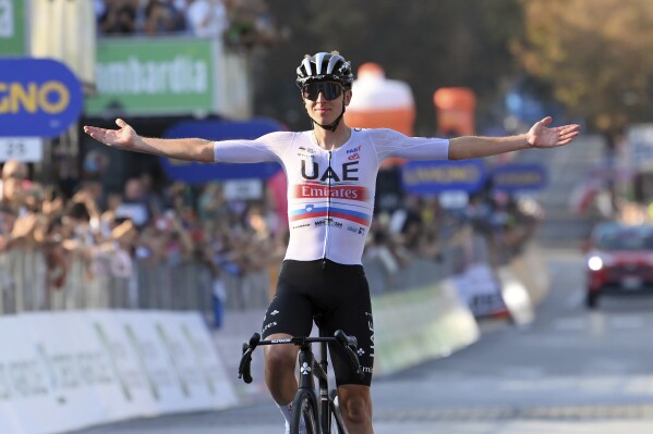 Tadej Pogacar celebrates as he crosses the finish line to win the tour of Lombardy cycling race, from Como to Bergamo, Italy, Saturday, Oct. 7, 2023. (Gian Mattia D'Alberto/LaPresse via AP)