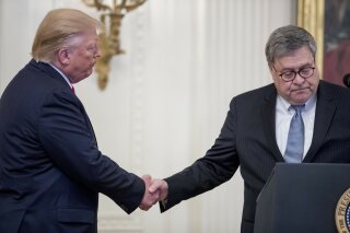 FILE - In this Sept. 9, 2019 file photo, President Donald Trump, left, shakes hands with Attorney General William Barr, right, as he takes the podium to present the Medal of Valor to six police officers for stopping a mass shooter in Dayton, Ohio, and Heroic Commendations to five civilians for their heroism during the mass shooting in El Paso, Texas, in the East Room of the White House in Washington. In offering Ukraine’s president the help of Attorney General William Barr in investigating rival Joe Biden, President Donald Trump is once again immersing the nation’s top law enforcement officer in the political fray. It’s a role Barr has seemed to embrace since taking command of the Justice Department in February. (AP Photo/Andrew Harnik)