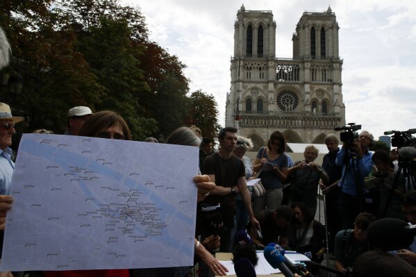 Environmental groups and unionists attend a news conference to warn against lead particles polluting the air in the area, and ask for a regularly updated chart showing pollution levels in Paris, France, Monday, Aug. 5, 2019. Hundreds of tons of toxic lead in Notre Dame's spire and roof melted during the April fire. (AP Photo/Francois Mori)