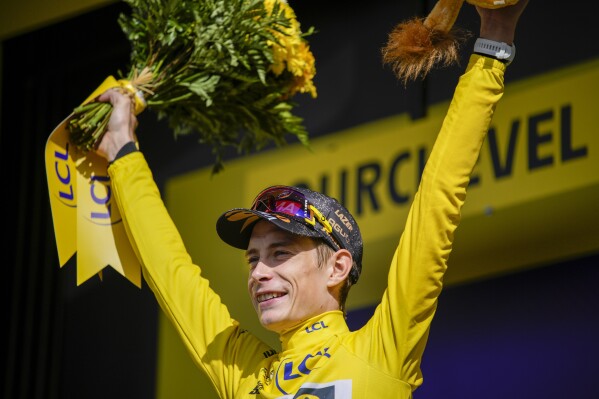 Denmark's Jonas Vingegaard, wearing the overall leader's yellow jersey, celebrates on the podium after the seventeenth stage of the Tour de France cycling race over 166 kilometers (103 miles) with start in Saint-Gervais Mont-Blanc and finish in Courchevel, France, Wednesday, July 19, 2023. (AP Photo/Daniel Cole)