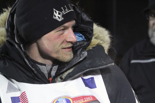 FILE - Dallas Seavey talks to officials after finishing the Iditarod Trail Sled Dog Race, March 15, 2016, in Nome, Alaska. The veteran musher had to kill a moose after it injured his dog shortly after the start of the 2024 Iditarod, race officials said Monday, March 4, 2024. (AP Photo/Mark Thiessen, File)