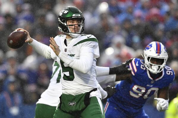 New York Jets quarterback Mike White (5) winds up to pass under pressure from Buffalo Bills defensive end Shaq Lawson (90) during the first half of an NFL football game, Sunday, Dec. 11, 2022, in Orchard Park, N.Y. (AP Photo/Adrian Kraus)